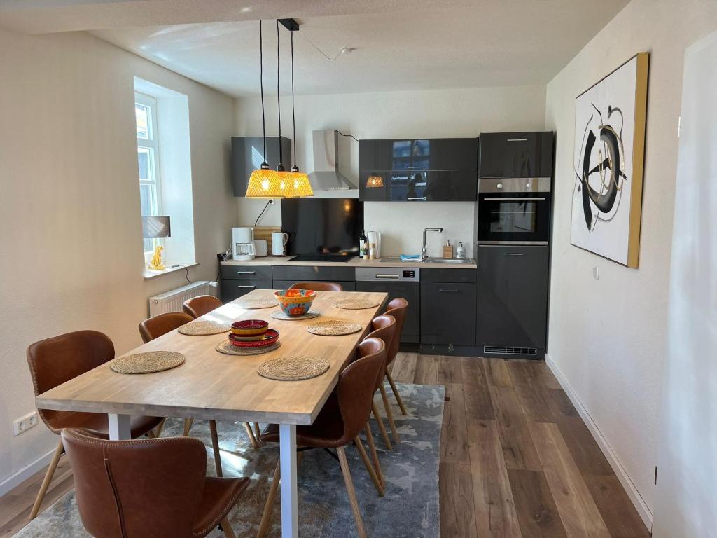 Una cocina con una mesa y sillas de madera. en Ferienwohnung Burgsitz, en Spangenberg