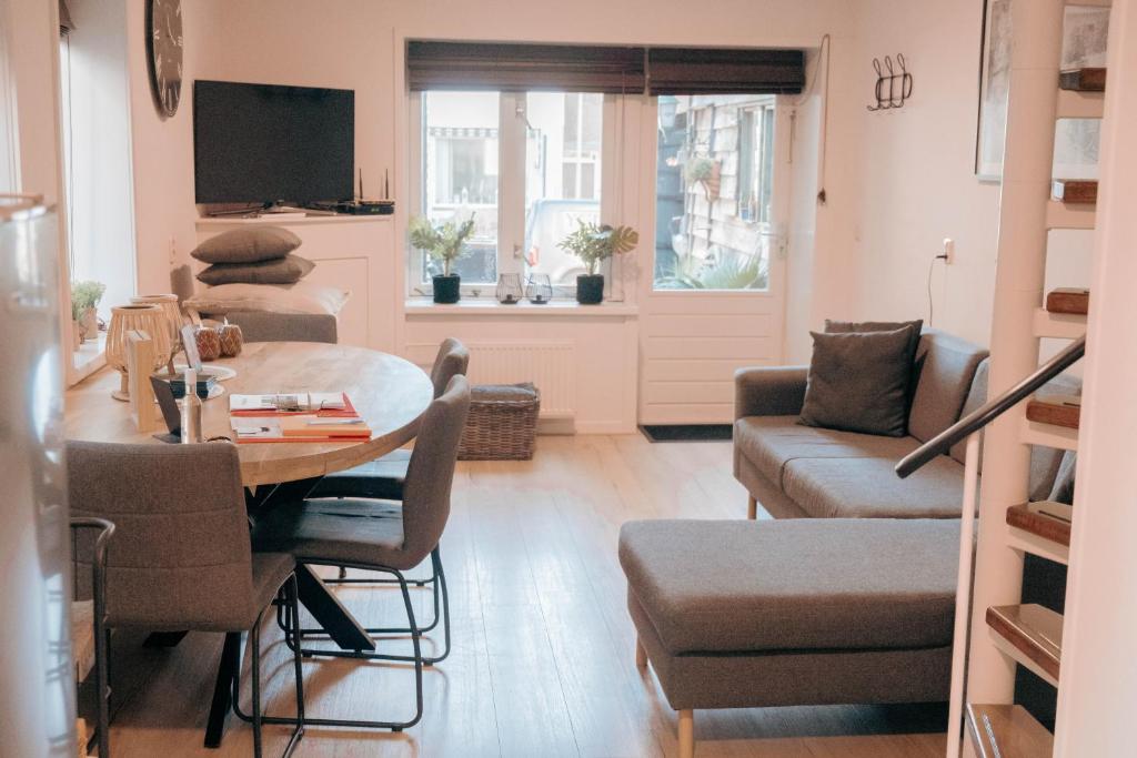 uma sala de estar com uma mesa e um sofá em 'T Heilige Pad em Egmond aan Zee
