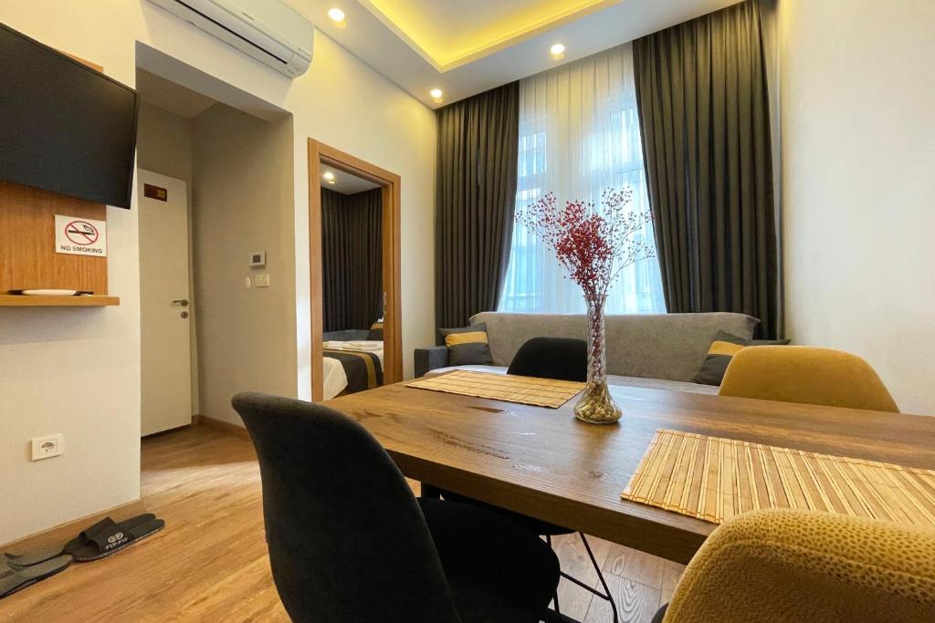 a dining room table with chairs and a vase with flowers at tidy 1BR apt near to nisantasi and Taksim #302 in Istanbul