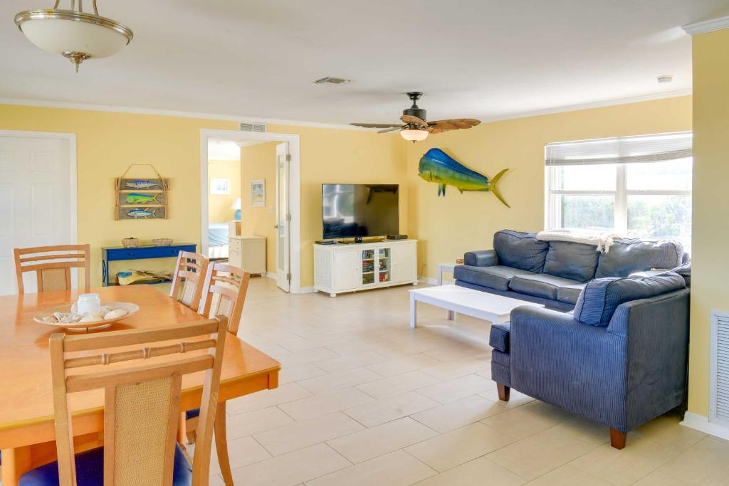 een woonkamer met een blauwe bank en een tafel bij Big Pine Key Home on Bogie Channel with Dock and Slip! in Big Pine Key