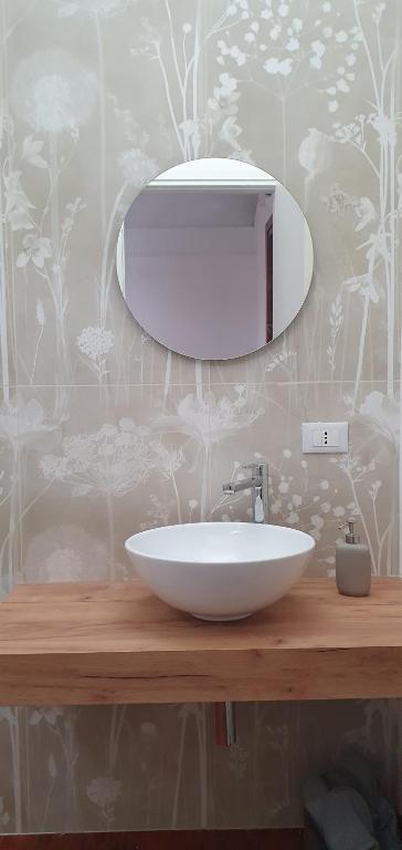 uma casa de banho com um lavatório branco e um espelho. em Gaia Suites em Turim