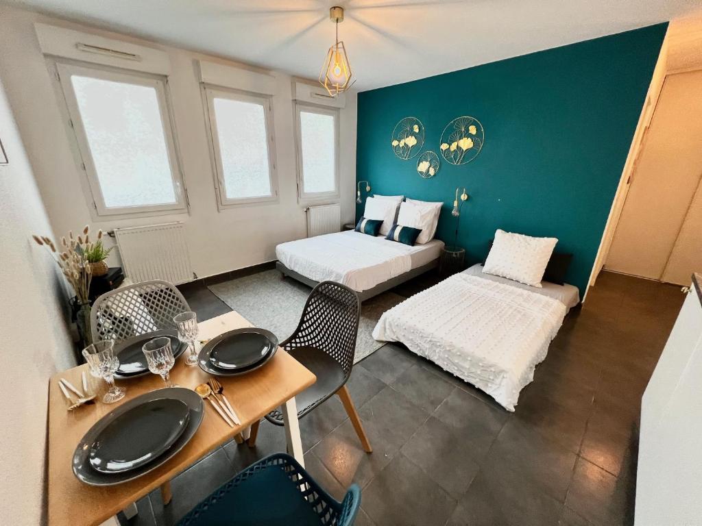 une chambre avec un lit, une table et des chaises dans l'établissement Agatha : ACCES FACILE GARE PARDIEU / EUREXPO / AEROPORT / GROUPAMA STADIUM, à Villeurbanne