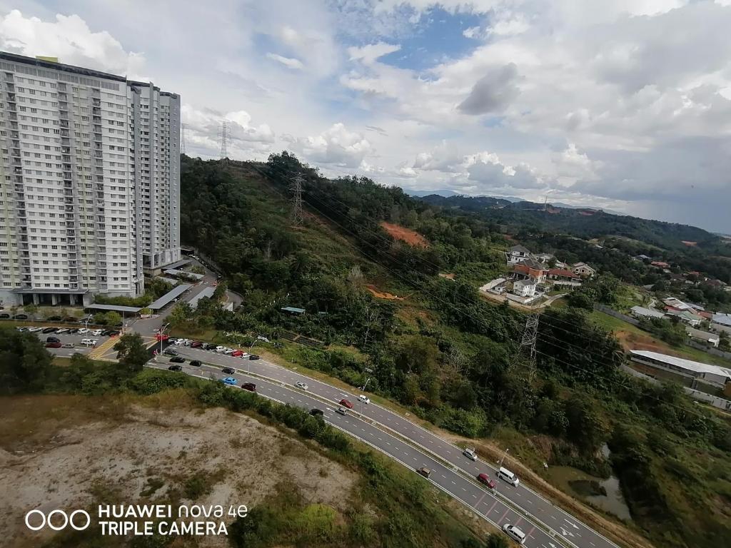 un grand bâtiment sur une colline à côté d'une route dans l'établissement KASTURI GUEST HOUSE PUTRAJAYA, à Putrajaya