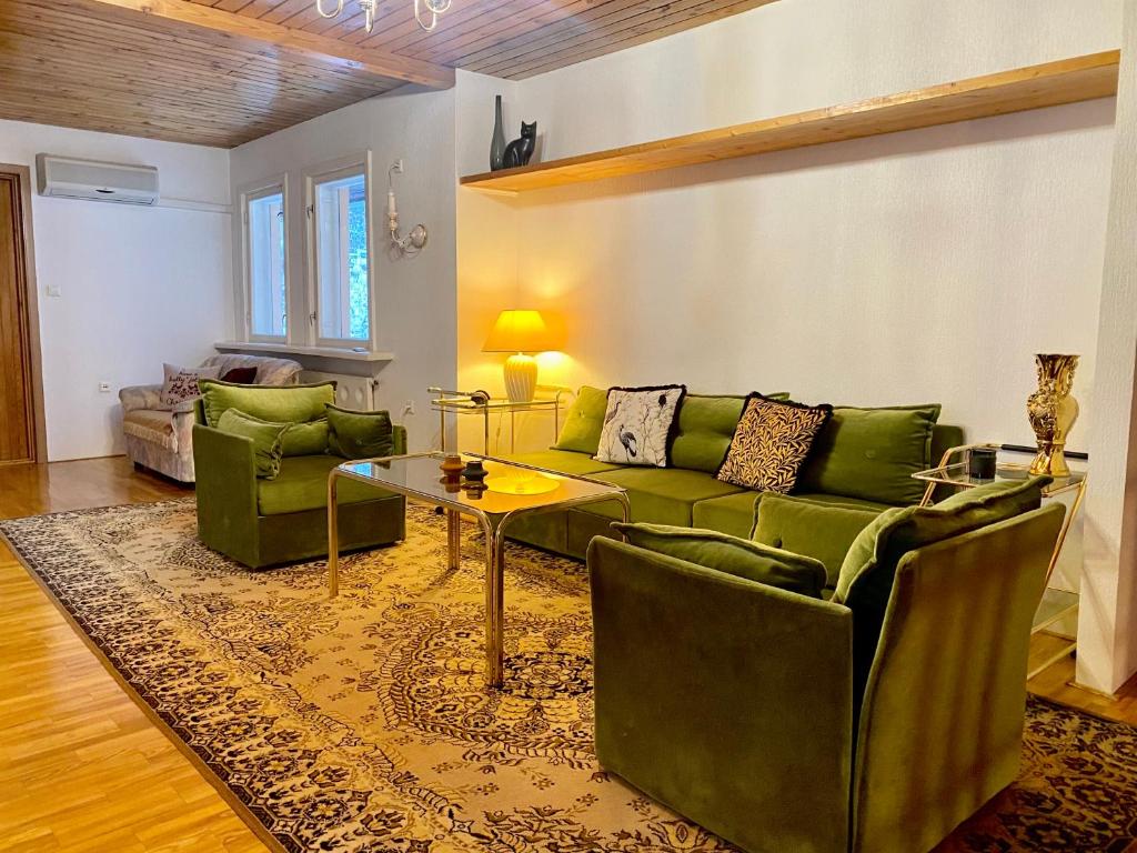 a living room with green couches and a table at Cozy home in Tallinn in Tallinn