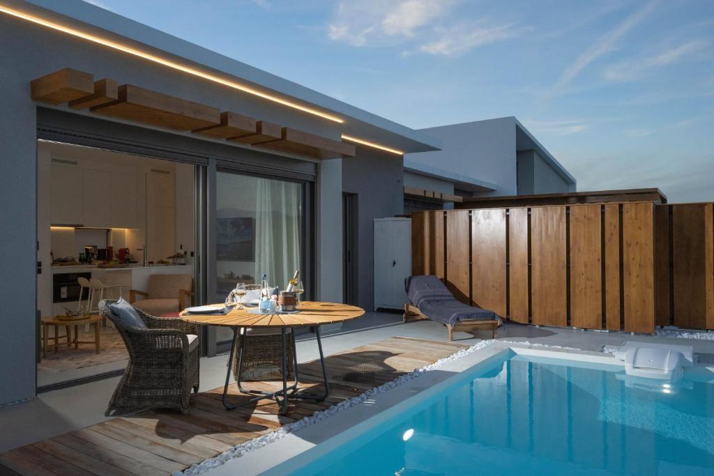 un patio con mesa y sillas junto a una piscina en AZIZA luxury suite en Tolón