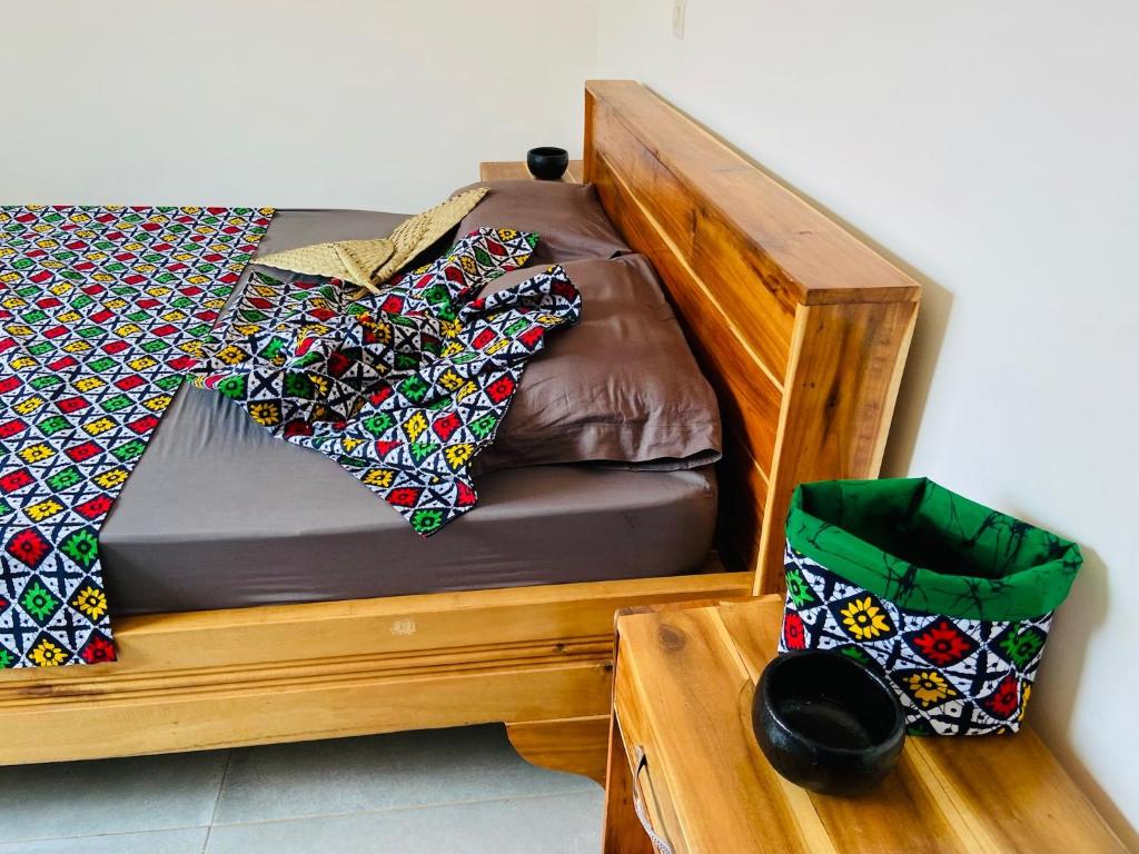 a wooden bunk bed with ties on it at Les Amazones Rouges Chambre Verte in Ouidah