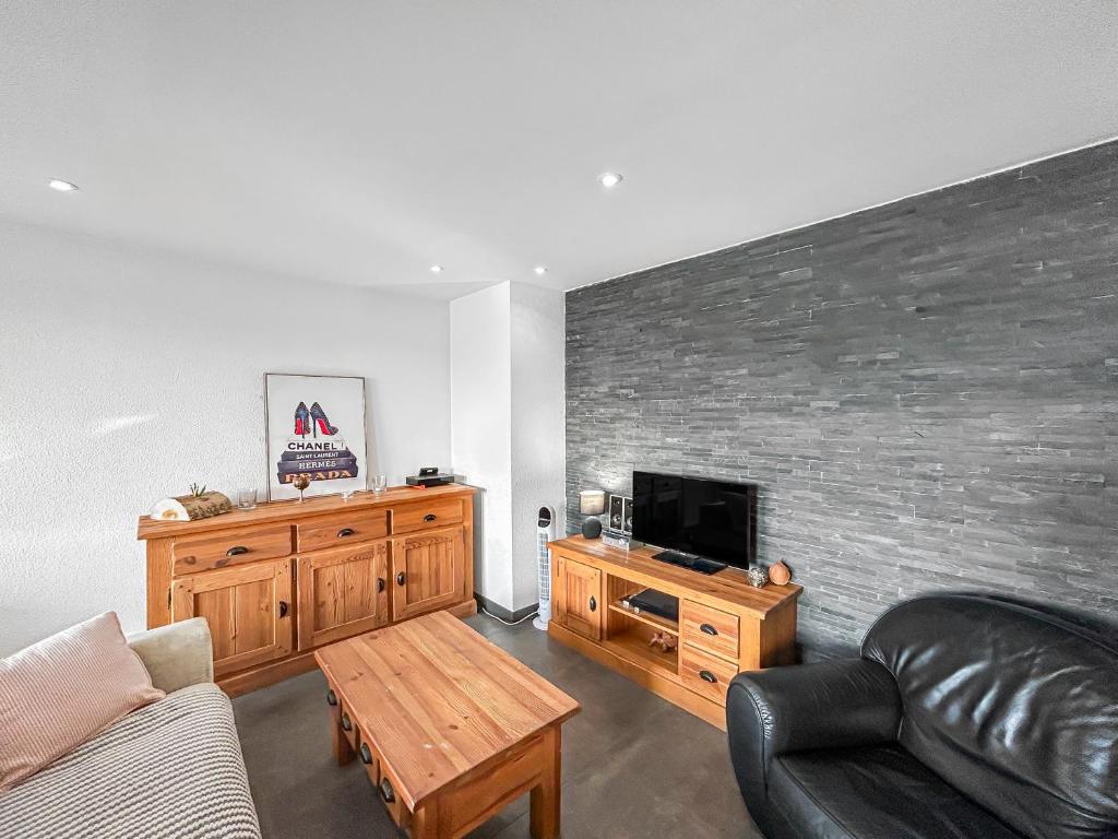 a living room with a couch and a flat screen tv at Escale Affaires Dugny-Bourget in Dugny