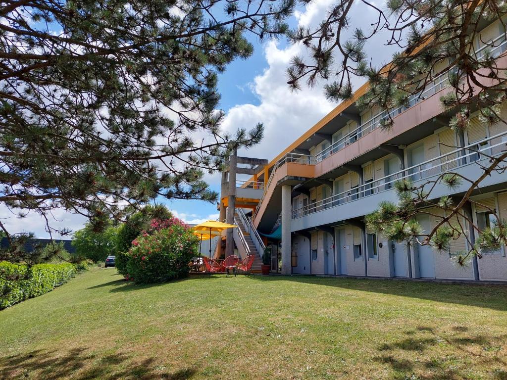 a building with a lawn in front of it at Premiere Classe Saintes in Saintes