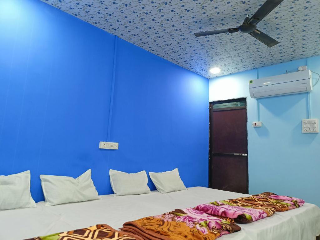a blue room with a bed and a ceiling at M Baba Guest House in Ujjain