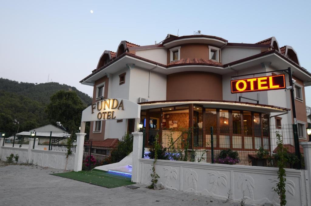 a hotel with a sign in front of it at Funda Hotel in Göcek