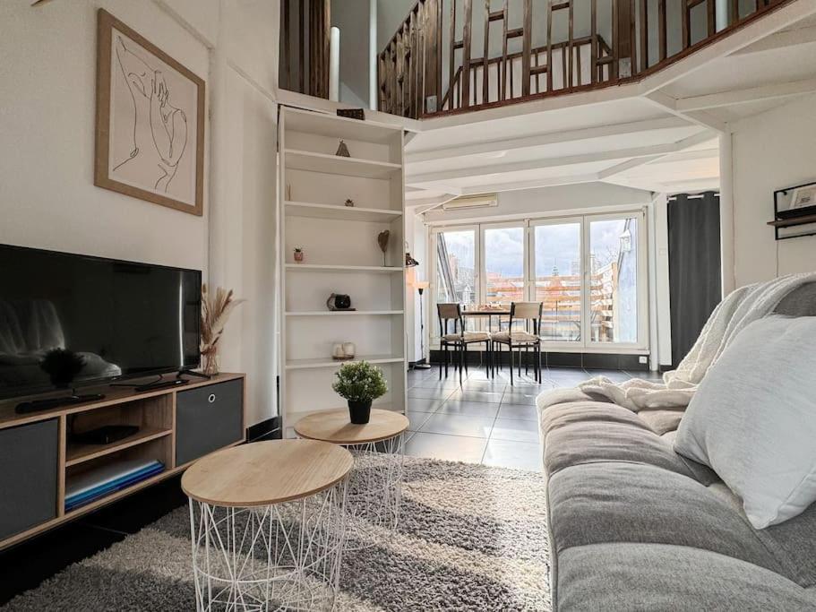 un salon avec un canapé et une télévision dans l'établissement Le coin de Paradis, proche centre ville, à Mulhouse