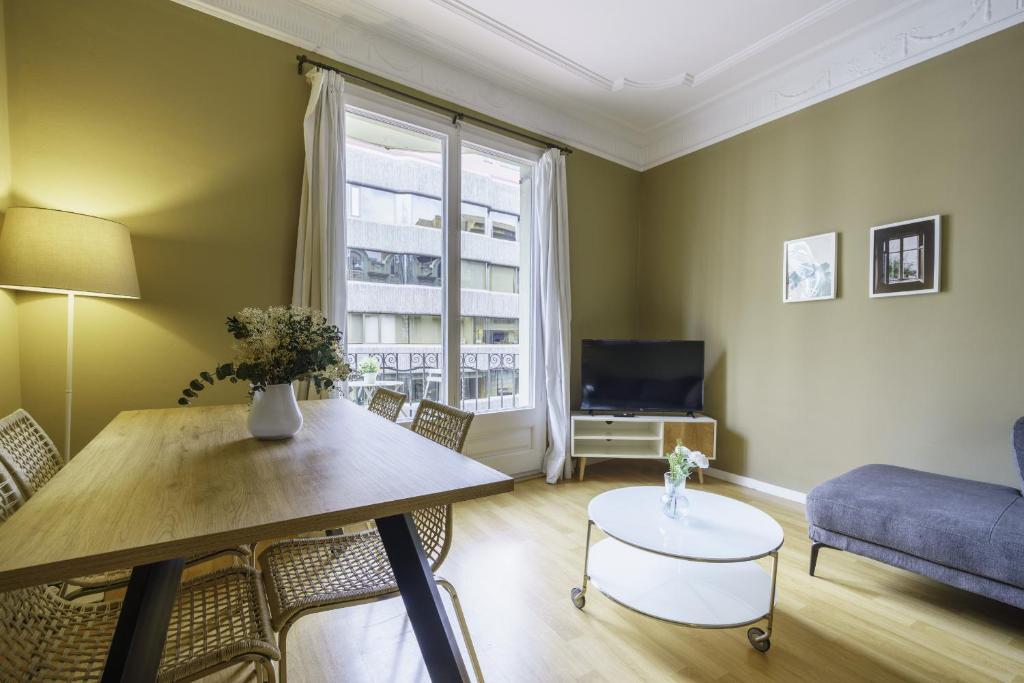 uma sala de estar com uma mesa e um sofá em Ola Living Aribau Apartments em Barcelona