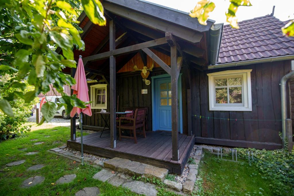 Leipe的住宿－Ferienhaus Paula，小屋设有带桌子和遮阳伞的甲板