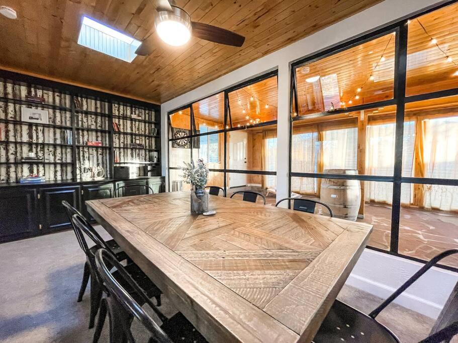 a large wooden table in a library with chairs at Peaceful Getaway / Heart of COS/mins to downtown in Colorado Springs