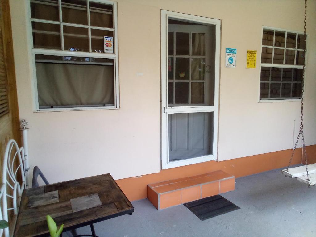 a building with two windows and a wooden bench at Cosy Corner in Saint Georgeʼs
