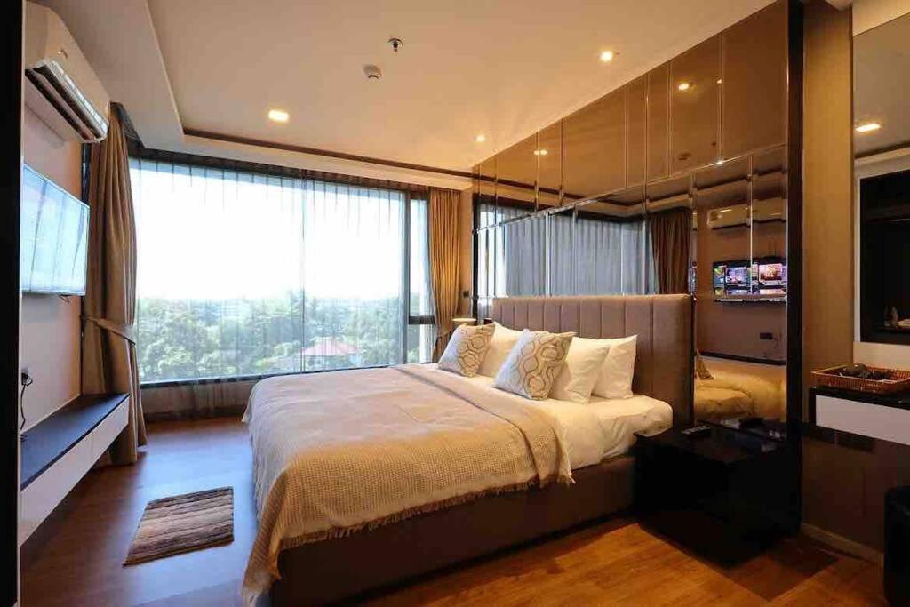 1 dormitorio con cama grande y ventana grande en Exclusive Living The Star Hill Condo Chiang Mai, en Chiang Mai