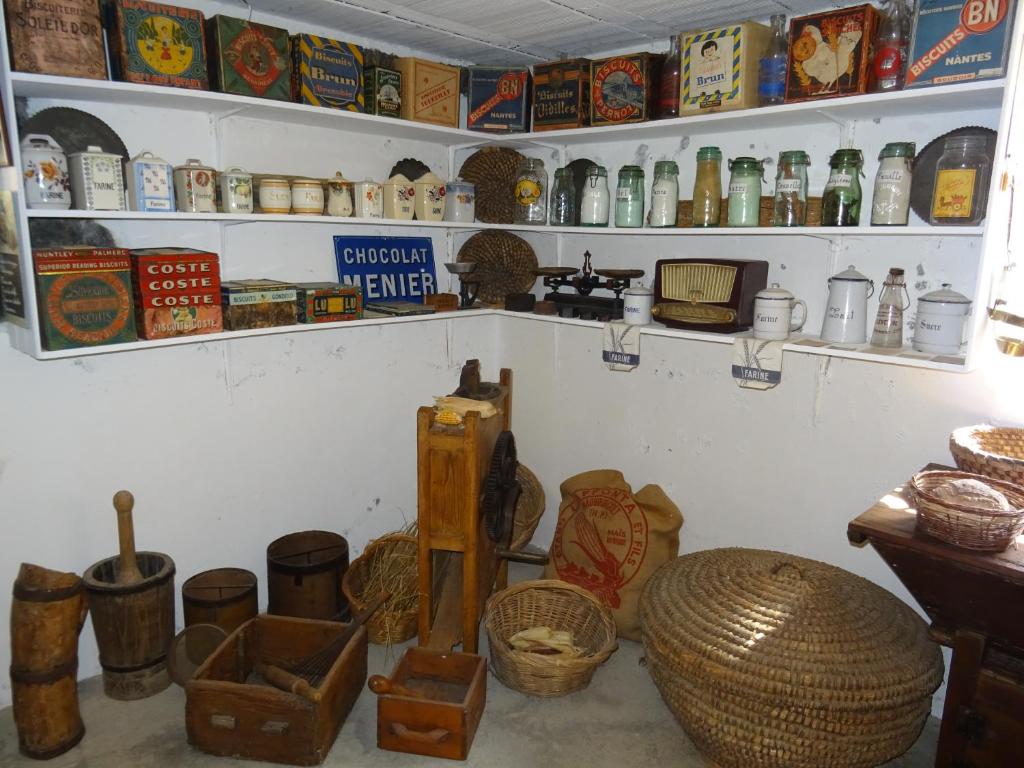 a room filled with lots of items on shelves at Le Clos Fleuri in Caumont