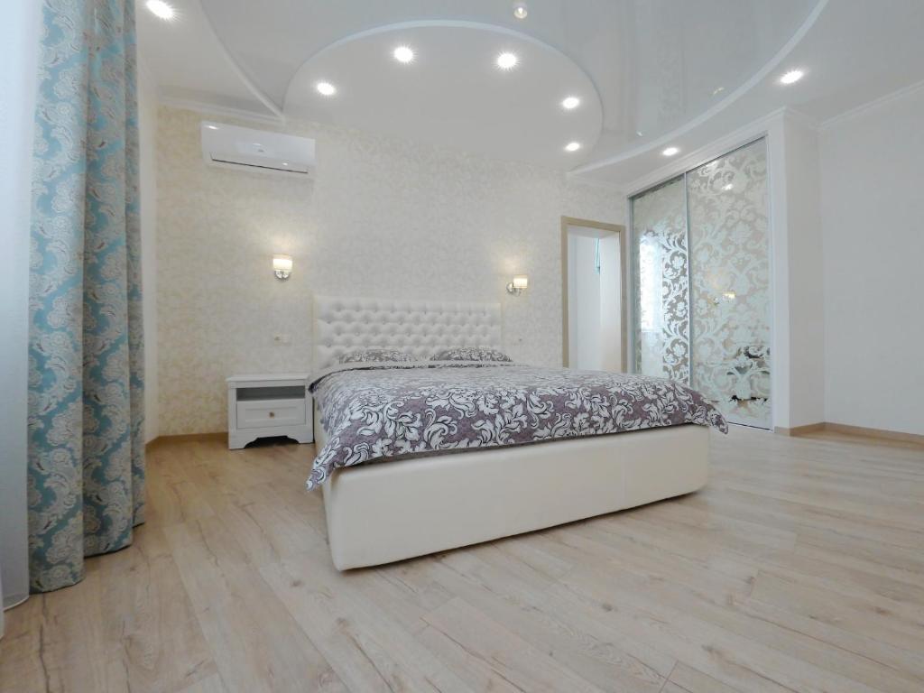 キーウにあるYulia apartment metro Osokorkiの白いベッドルーム(ベッド1台、大きな窓付)