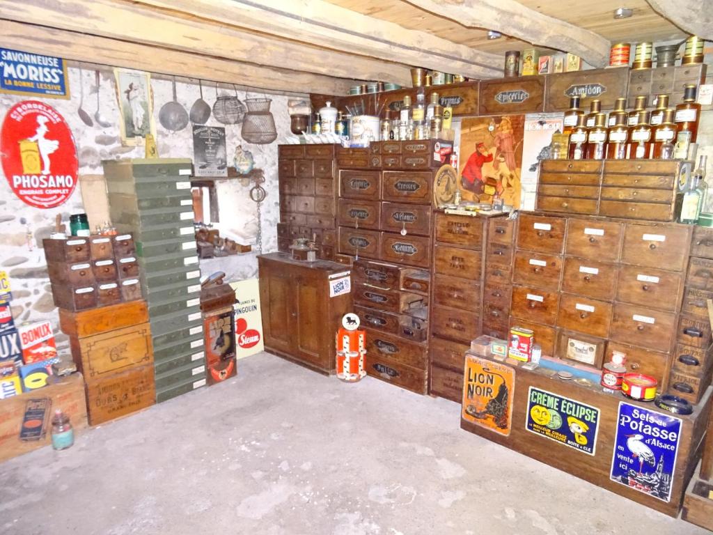 a room with lots of wooden chests and cabinets at Le Clos Fleuri in Caumont