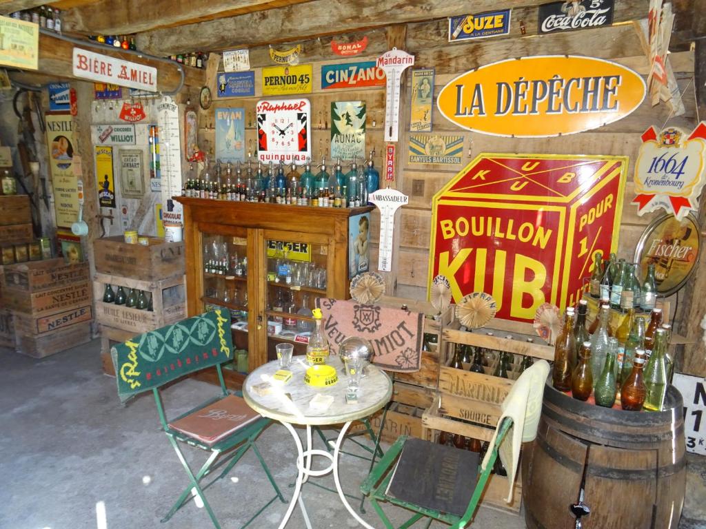 a room with a table and some bottles of alcohol at Le Clos Fleuri in Caumont