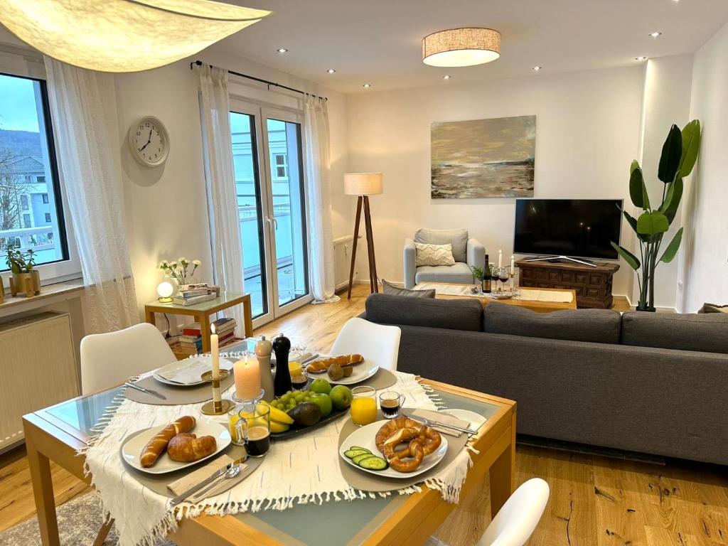 ein Wohnzimmer mit einem Tisch mit Essen drauf in der Unterkunft Boutique L´AHRpartement Ahr-Terrasse-Zentral in Bad Neuenahr-Ahrweiler