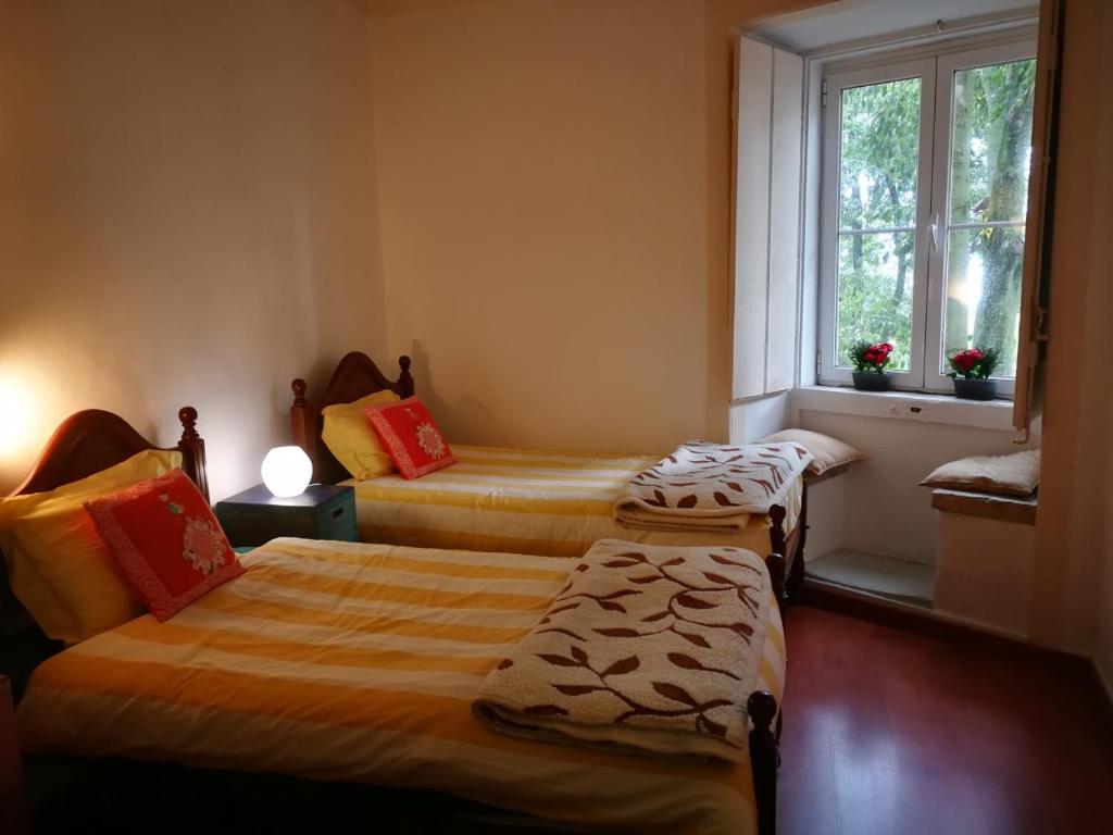 - une chambre avec 2 lits et une fenêtre dans l'établissement Casa Vovo, à Lisbonne