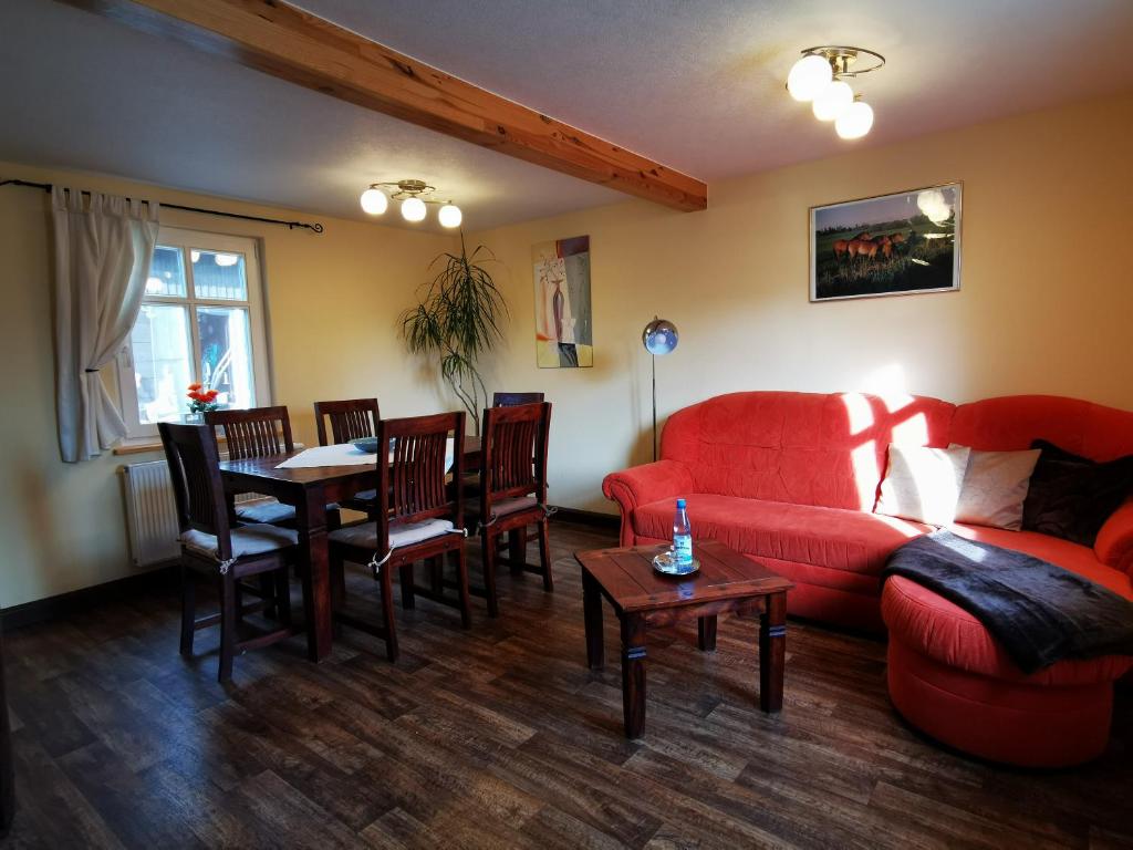 sala de estar con sofá rojo y mesa en Ferienhaus Layla, en Leipe