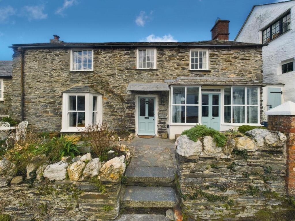 a stone house with a blue door and windows at Myrtle Cottage Boscastle in Boscastle