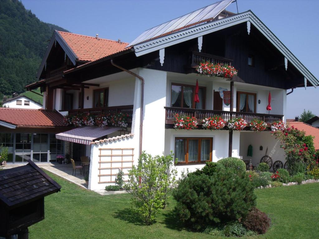 a white house with flowers on the balconies at Ferienwohnungen Schweiger in Ruhpolding