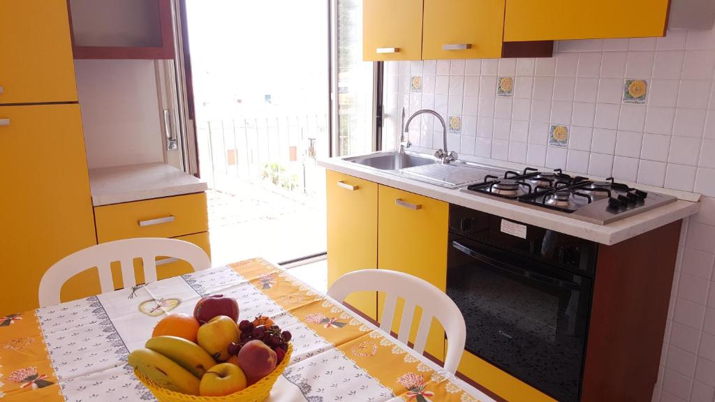 una cocina con una mesa con un bol de fruta. en SanMarco Holiday Home en Ascea