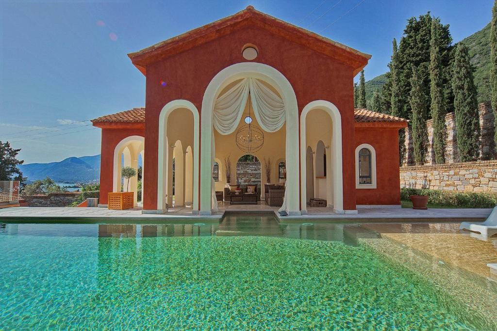a house with a swimming pool in front of a house at Villa Veneziano in Nydri