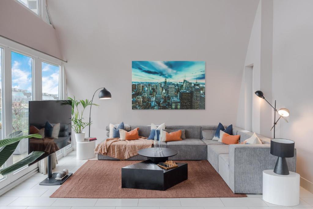 uma sala de estar com um sofá e uma mesa em Divine Views from a Breathtaking LuxXe City Penthouse for a Gracious Life Style em Londres