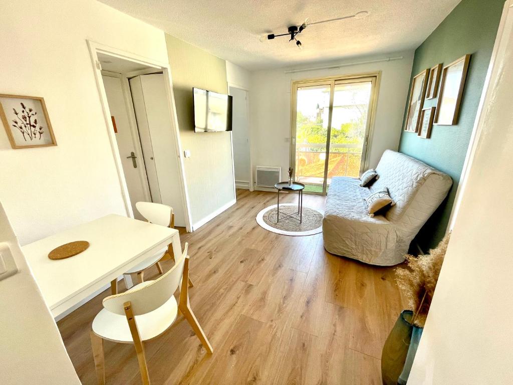 a living room with a couch and a table at Bel appartement Saint Raphaël in Saint-Raphaël