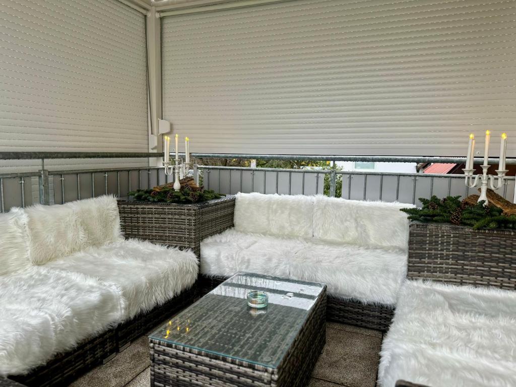 un salon avec des canapés blancs et une table dans l'établissement Ferienwohnung Schweier - Außerhalb und doch zentral, à Fribourg-en-Brisgau