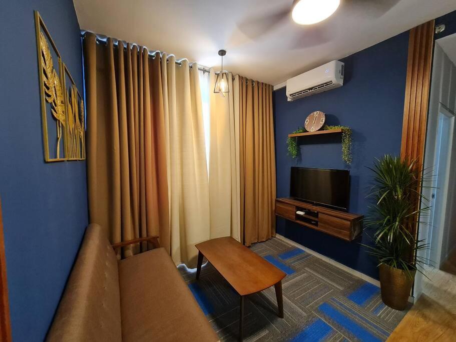 a living room with a couch and a television at Luxury Tangerine Suites KLIA in Sepang