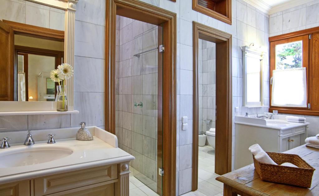 a bathroom with a sink and a toilet and a tub at Villa Veneziano Suites & Villa in Nydri