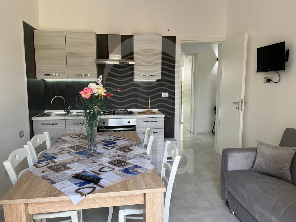 een eettafel met een vaas met bloemen erop bij Marks House - Spiaggia a 300m By Cala Salento in Porto Cesareo