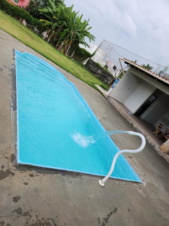 a large blue pool with a white hose on the ground at Casa ponta do sol in Capitólio