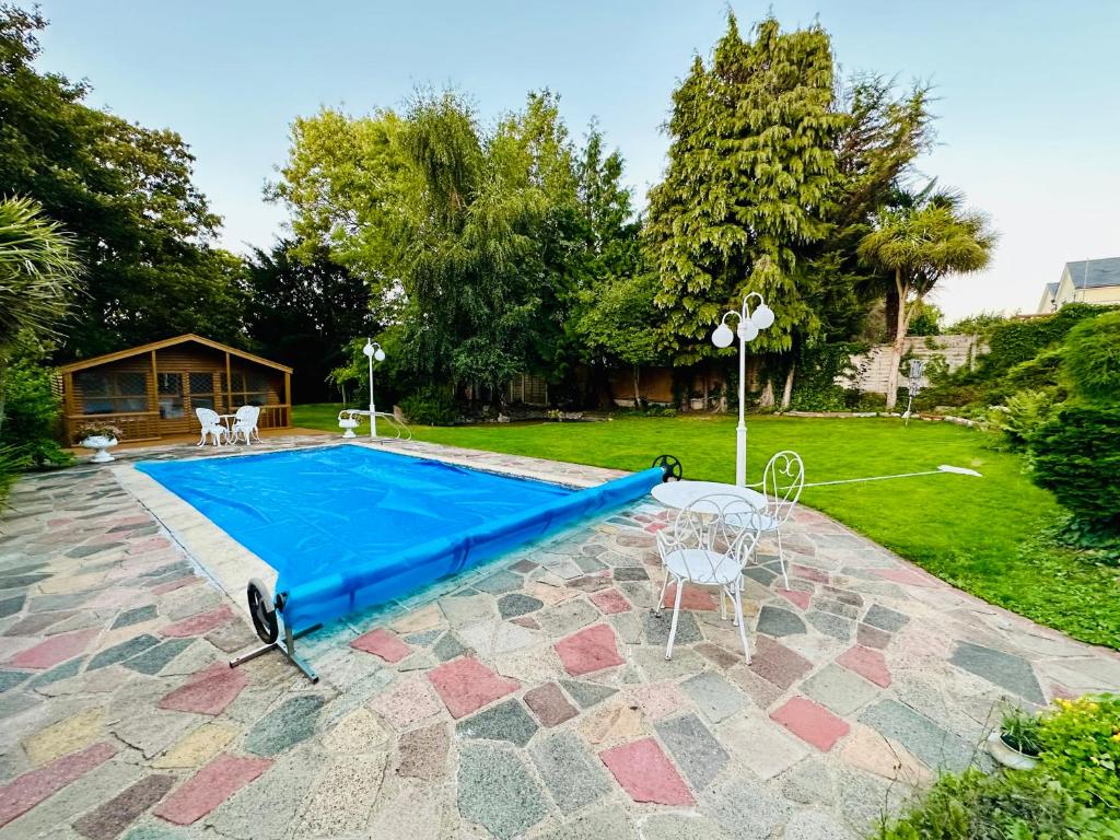 a swimming pool with a blue cover on a patio at Magnificent 5 bedrooms London house in Bromley
