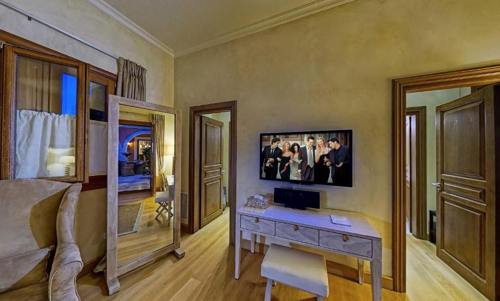 a bedroom with a desk and a bed and a mirror at Villa Veneziano Suites & Villa in Nydri