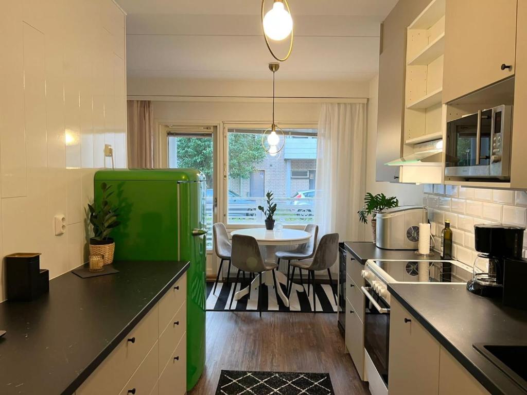 a kitchen with a green refrigerator and a table at Viihtyisä kaksio Annalassa, Free parking & Sauna in Tampere