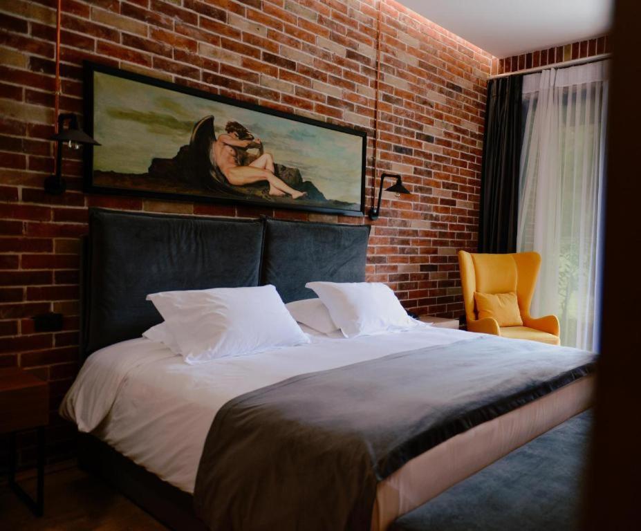 Cama en habitación con pared de ladrillo en Rozafa Fish City Hotel, en Labinot i Poshtëm