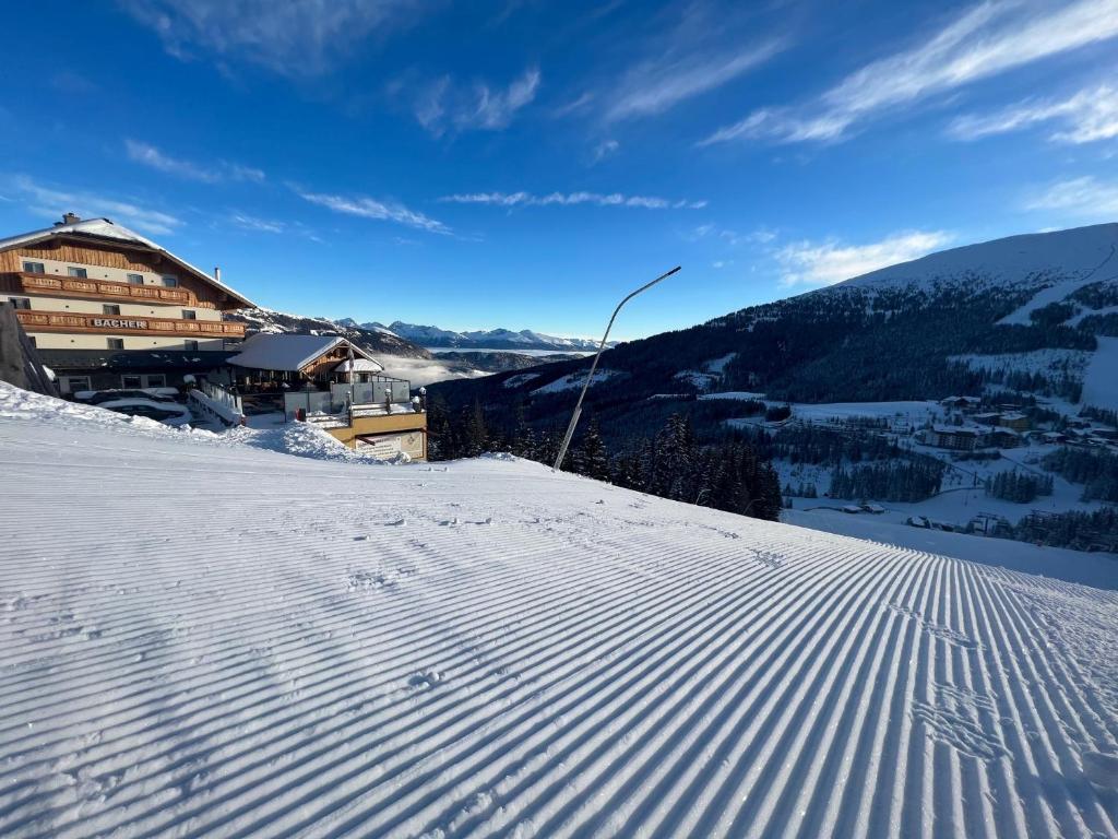 uma encosta coberta de neve com um edifício ao fundo em Gasthof Bacher em Katschberghöhe