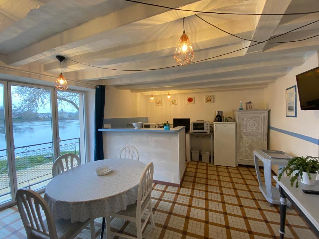 a kitchen and dining room with a table and a table and chairs at Maison du pêcheur , située sur les bords de la Loire dans un lieu calme et paisible. in Rochefort-sur-Loire