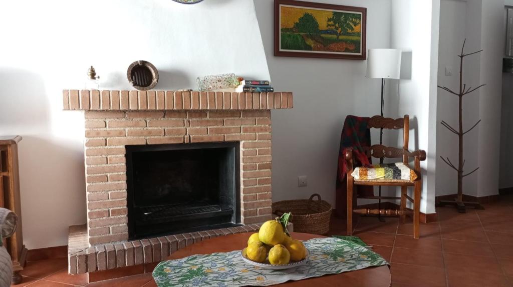 una sala de estar con chimenea y un montón de plátanos en una mesa en VyVE Grazalema AT, en Grazalema
