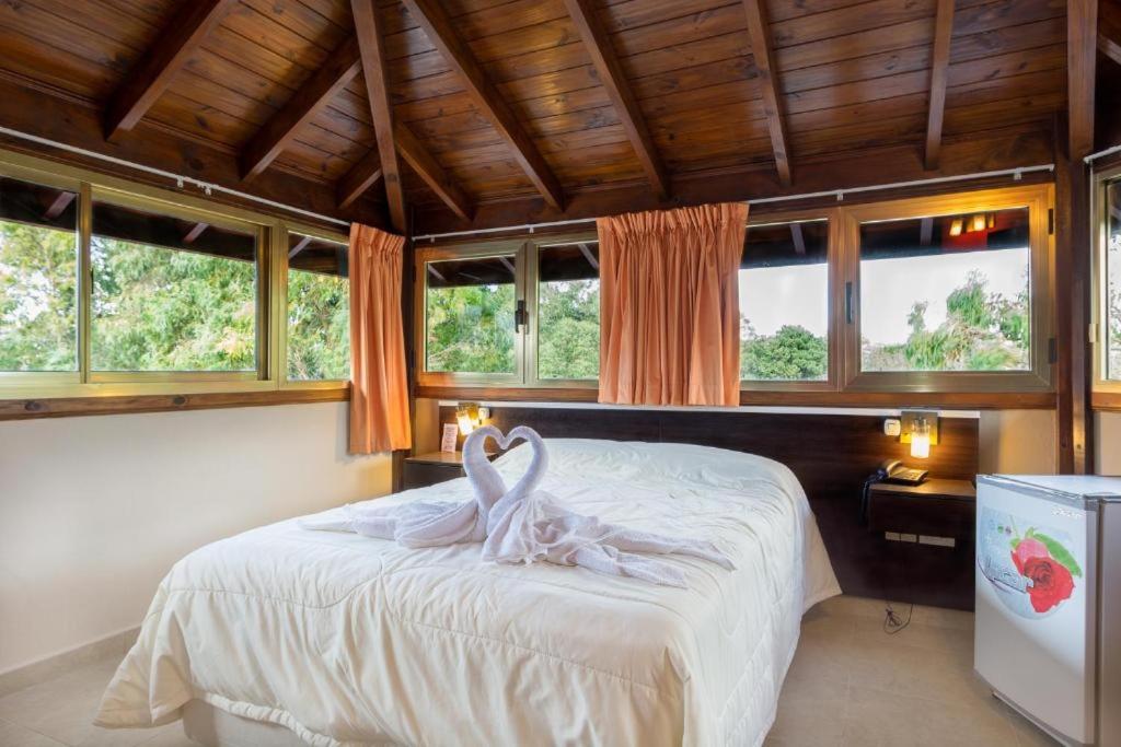 een slaapkamer met een bed met een zwaan erop bij Piedras Doradas Hotel y Spa in Valeria del Mar