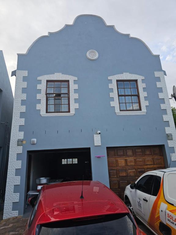 a blue house with a car parked in front of it at 9 Lourens River in Cape Town