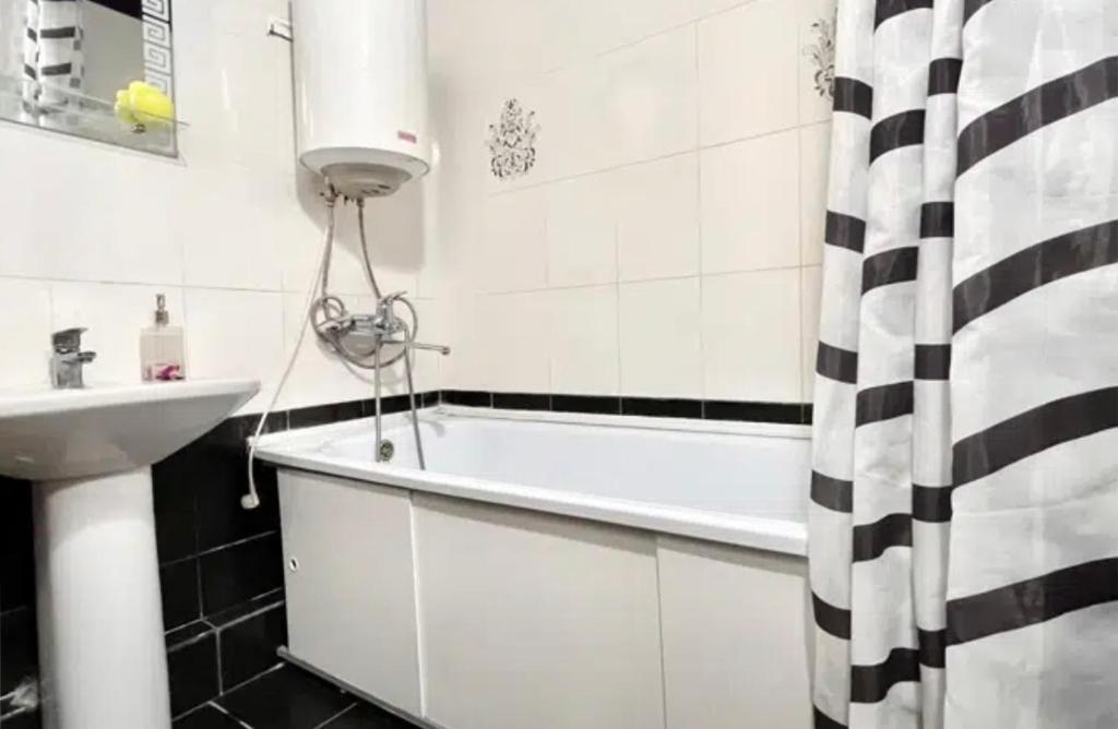 uma casa de banho com uma banheira e um lavatório em VIP apart 572 em Tbilisi