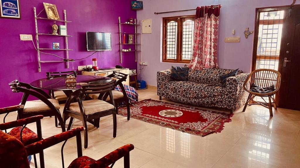 a purple living room with a table and a couch at HIlltop Cottage Homestay in Ooty