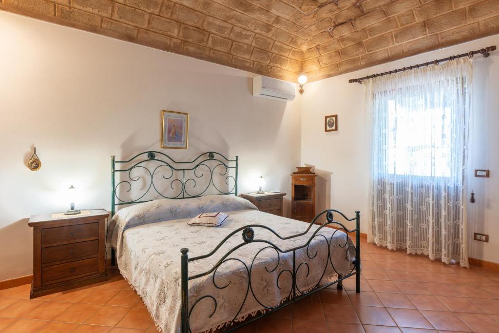 um quarto com uma cama grande e uma janela em Casa Cris em Castelluzzo